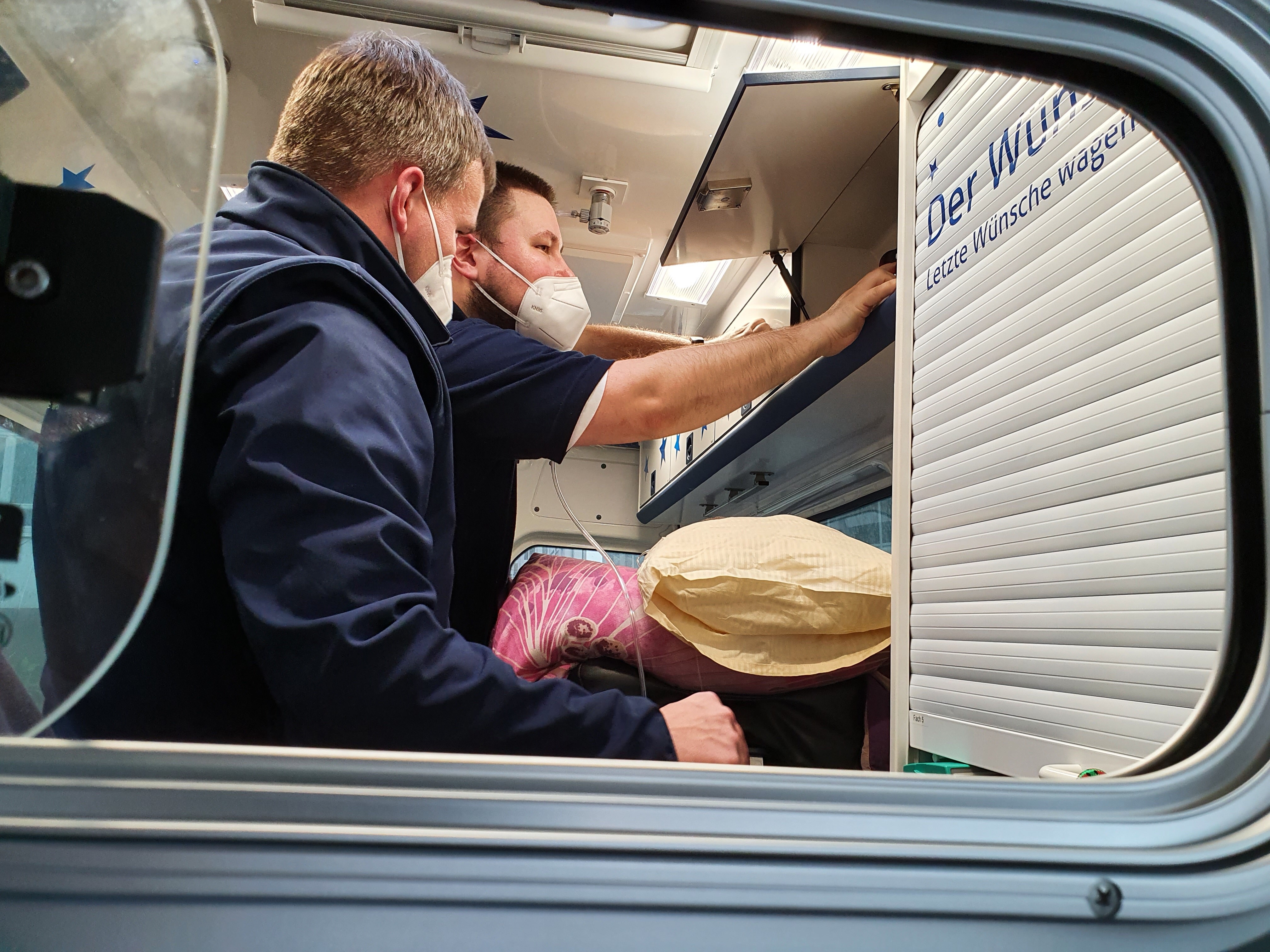 Die Wunscherfüller Maik Döring und Marc-Oliver Berndt kümmer sich im Wünschewagen um Fahrgast Jens Prügner.JPG